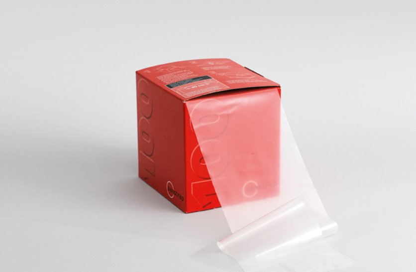 Sanstrap® Dehnband-Spenderbox mit herausgezogenem transparentem Band zur Palettensicherung.